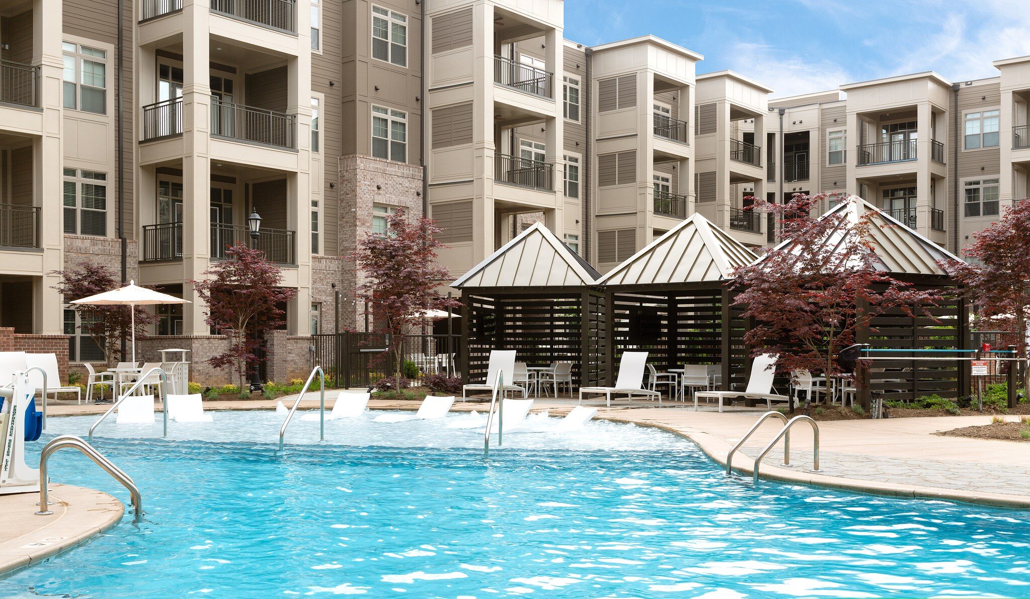 Luxury outdoor pool with lounge seating at Providence Row Apartments