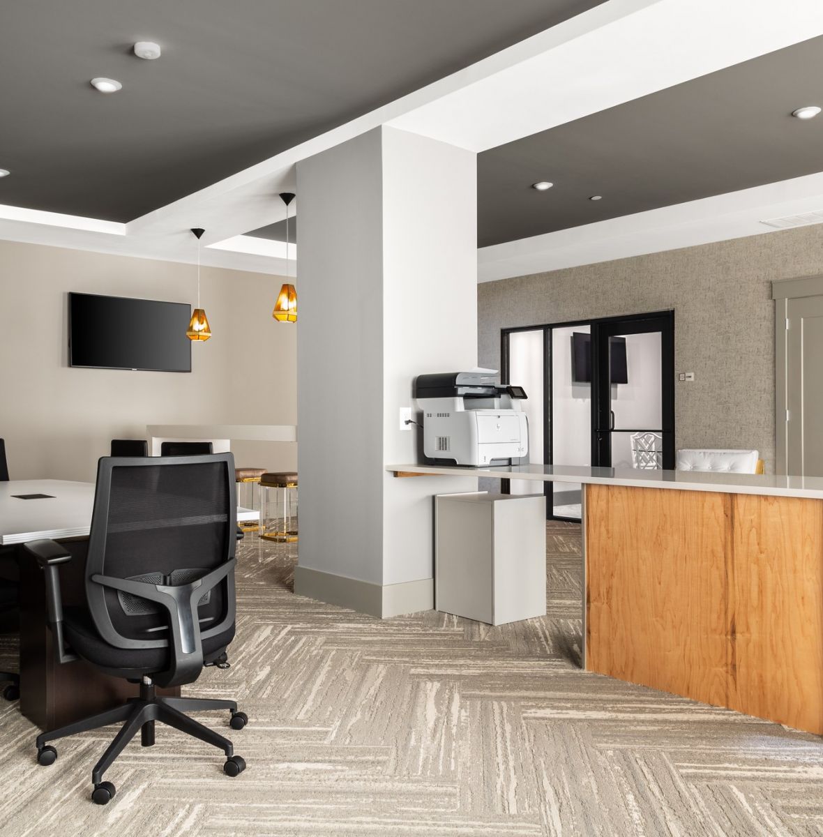 Business hub for residents at Providence Row with printer, conference table, TV, and more seating