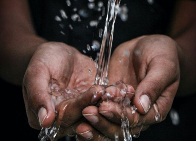 Two hands cupping pouring water