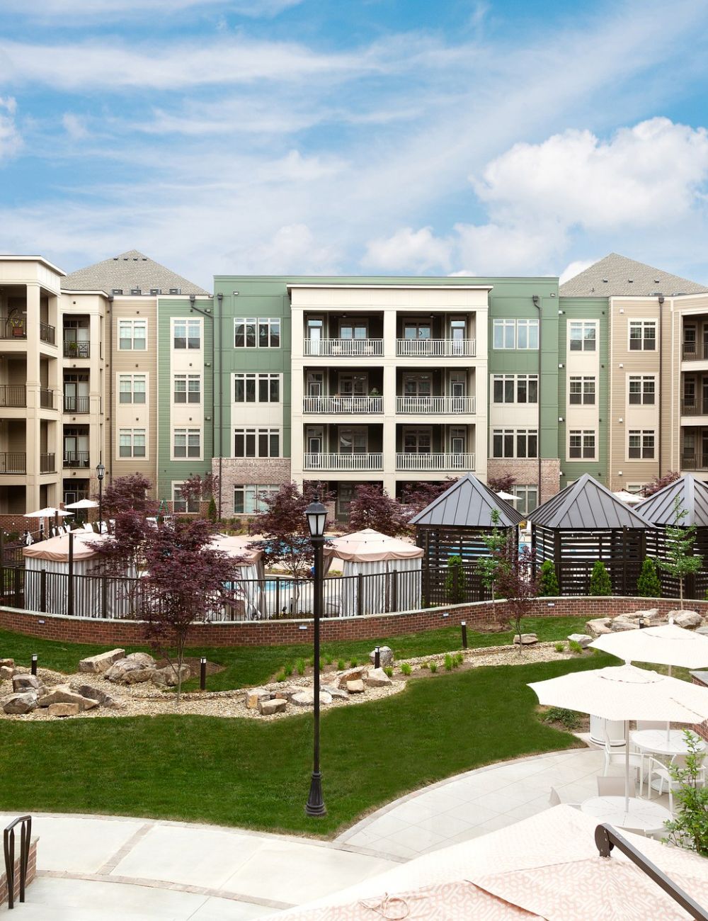 Exterior courtyard at Providence Row Apartments with beautiful landscaping, fireplace seating, and private cabanas