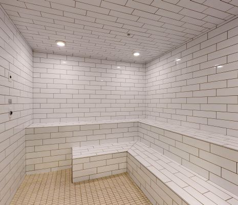 Inside of steam room with white tile walls at Providence Row Apartments