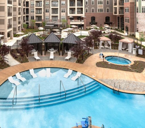 Luxury outdoor pool and hot tub with lounge seating and private cabanas at Providence Row Apartments
