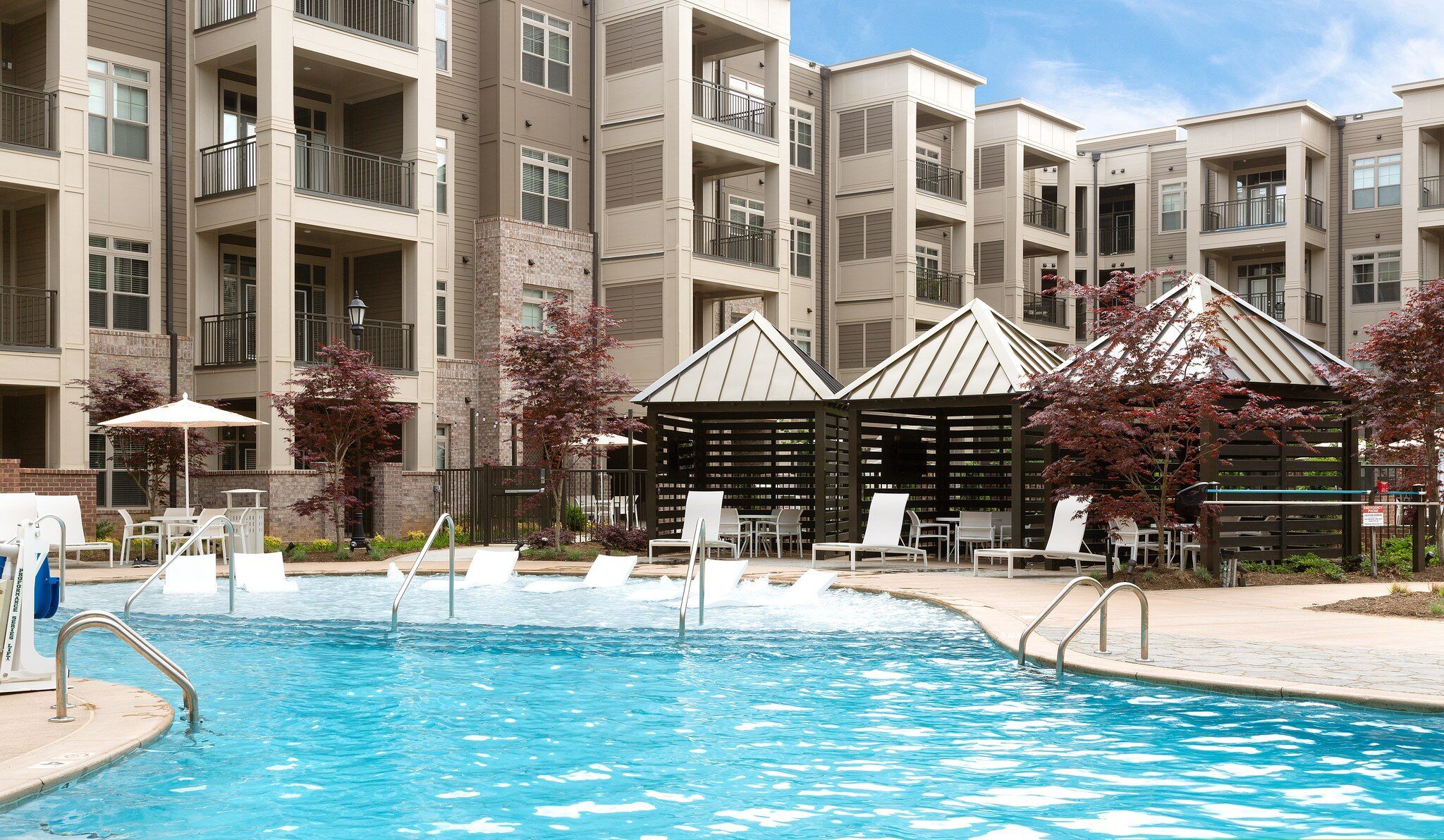 Luxury outdoor pool with lounge seating at Providence Row Apartments