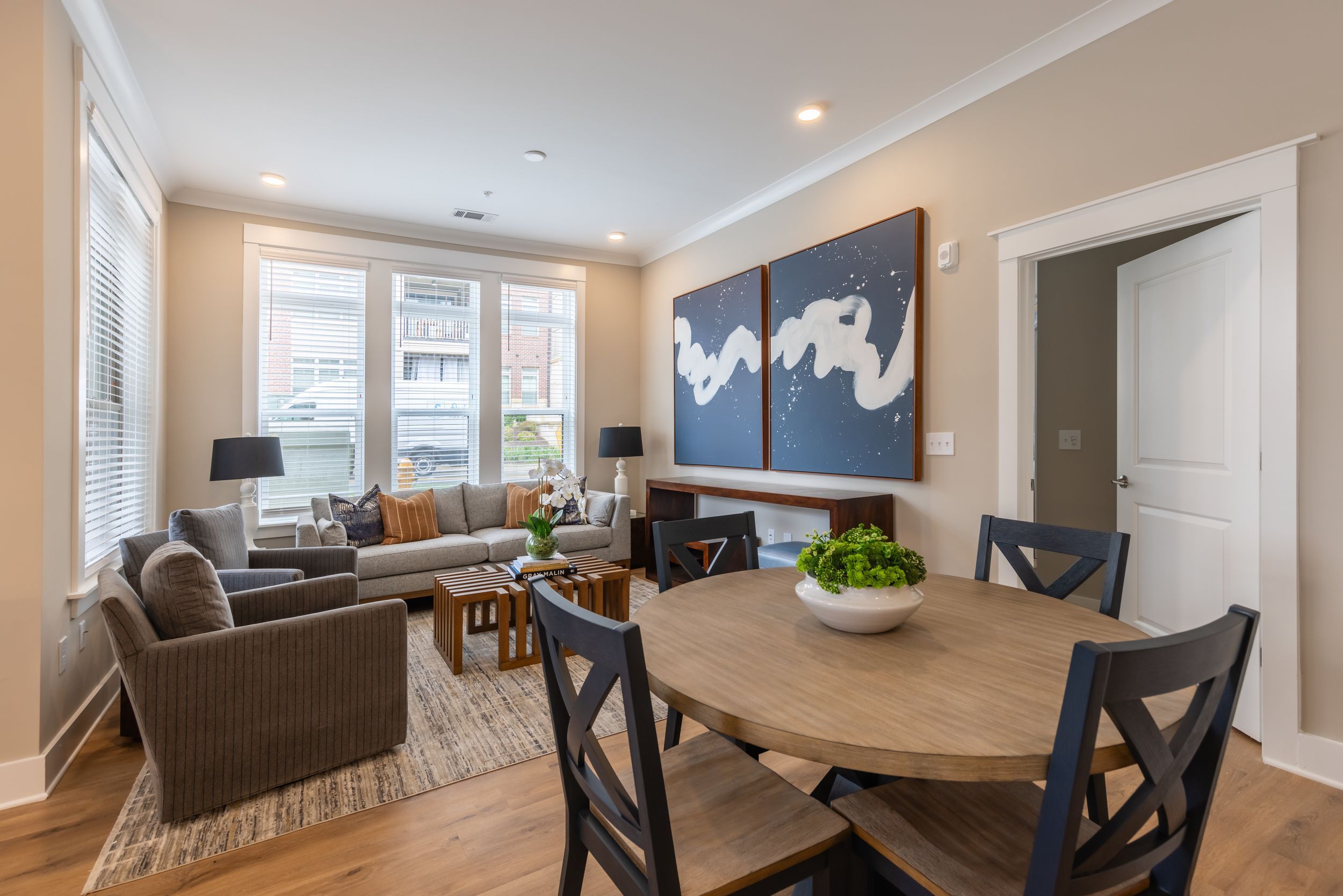 Apartment kitchen with luxury vinyl flooring, custom kitchen island, beautiful gray cabinetry, and lots of natural light