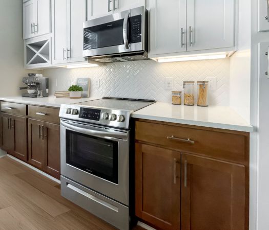 Two-tone cabinetry in luxury apartment kitchen with the bottom cabinets having a wood finish and the top cabinets being white