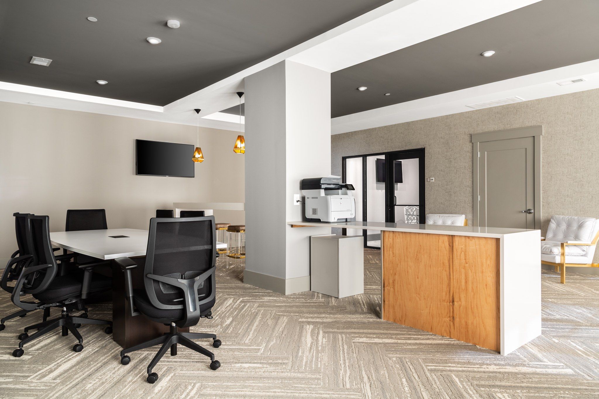 Business hub for residents at Providence Row with printer, conference table, TV, and more seating
