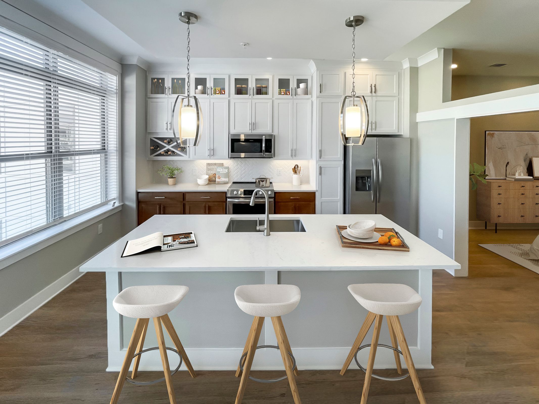 Luxury apartment interior showing kitchen island, luxury vinyl plank flooring, and stainless steel appliances
