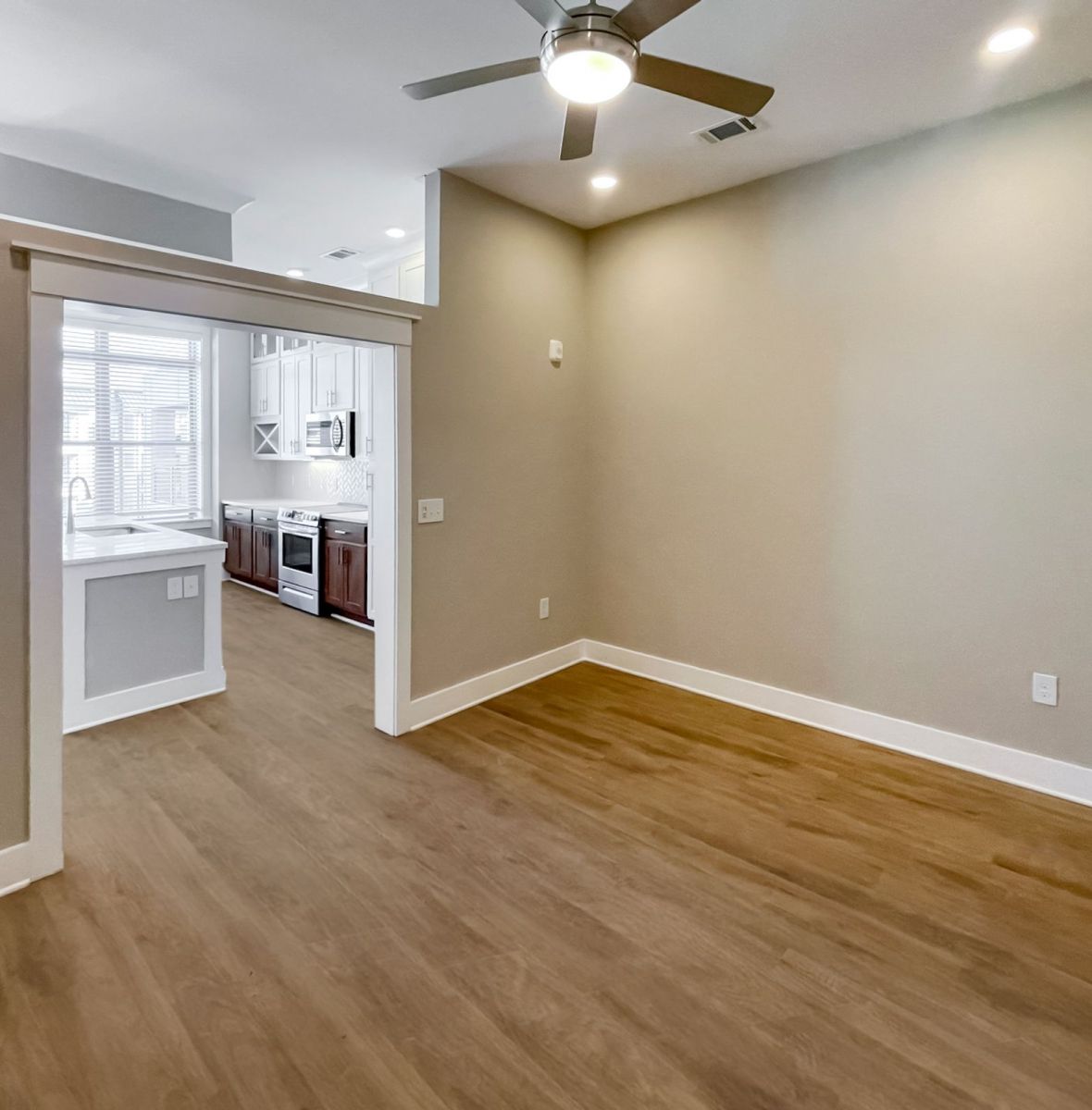 Luxury Charlotte apartment interior with vinyl plank, kitchen island, and ceiling fan